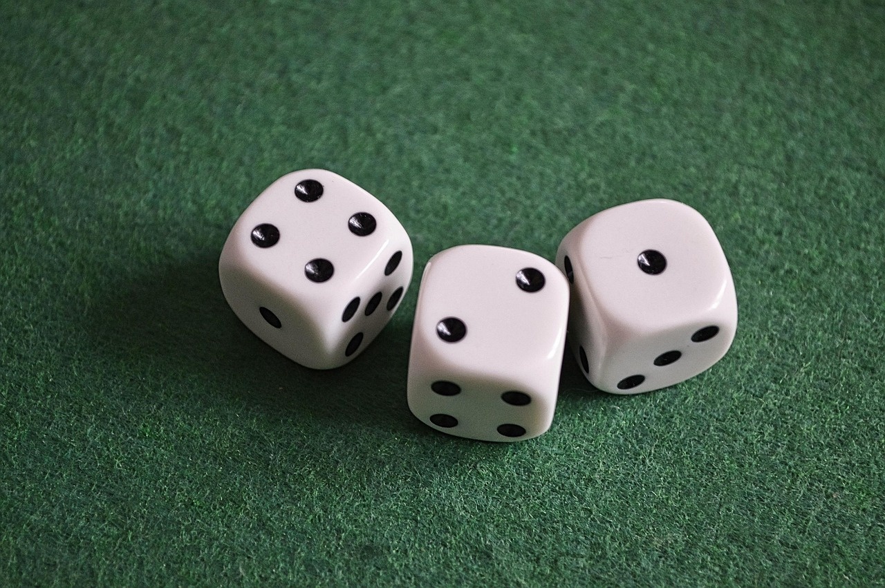 Three white dice resting on green gaming felt