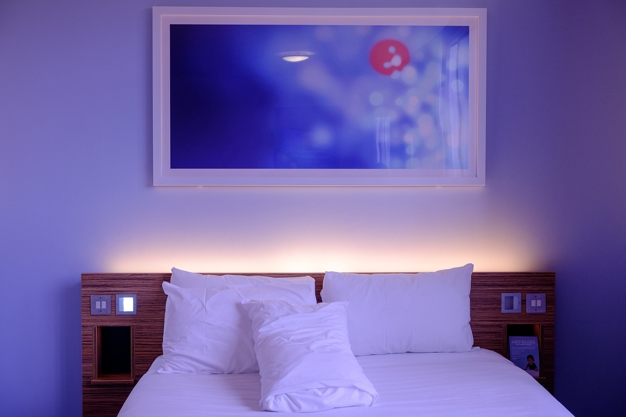 Moonlit bedroom with white linens, walnut headboard and cool indigo light