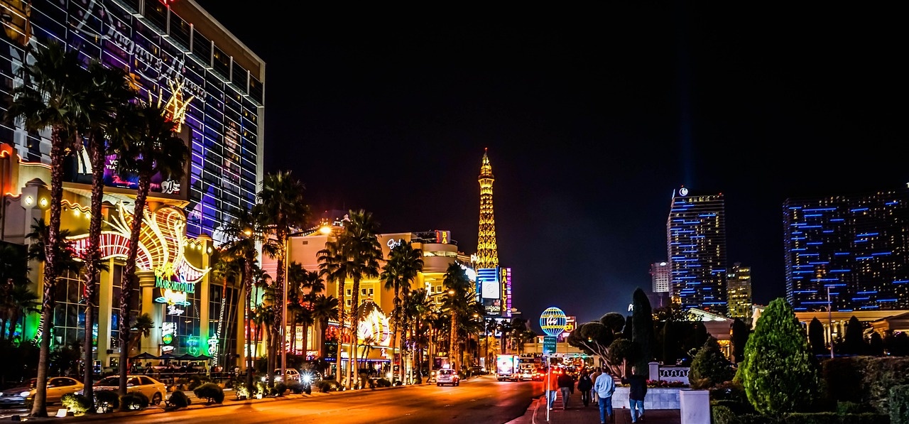 Evening boulevard with hotel lights, trees and a glowing skyline