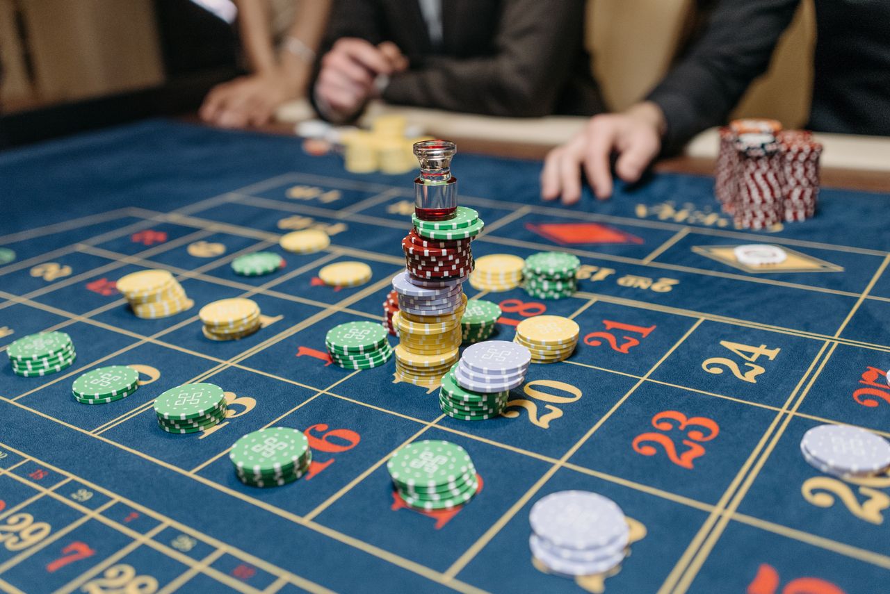 Roulette layout in deep navy felt with a glass marker on a stack of chips