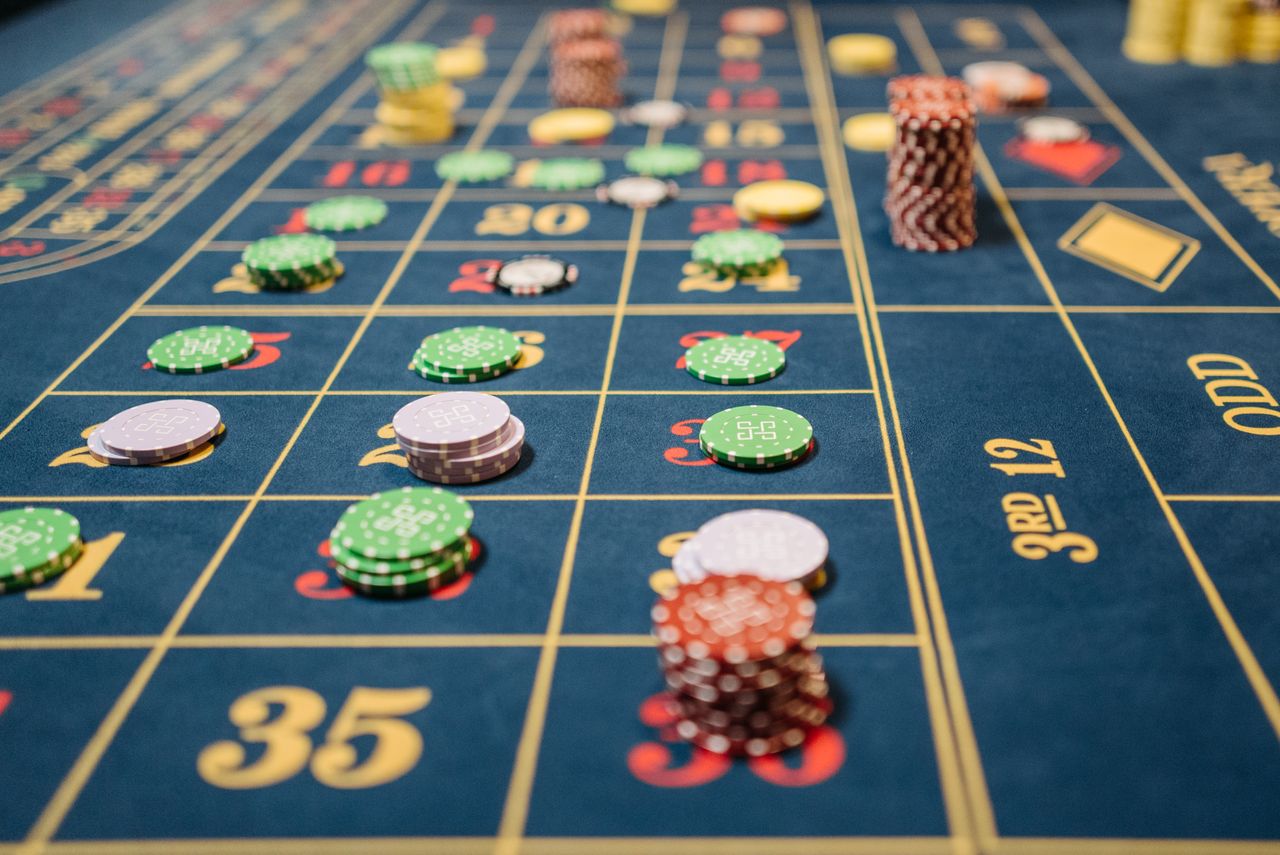 Midnight-blue roulette cloth with champagne markings and stacked chips